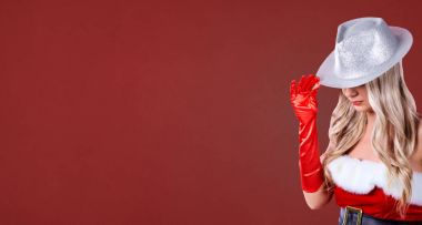 Noel Baba kostümlü kırmızı Noel arka plan üzerinde bir kız.