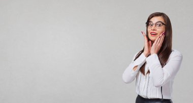 Gri bir arka plan üzerinde sürpriz duygular ile işadamı.