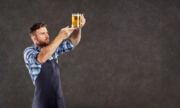 Пивовар со стаканом пива в руке — стоковое фото