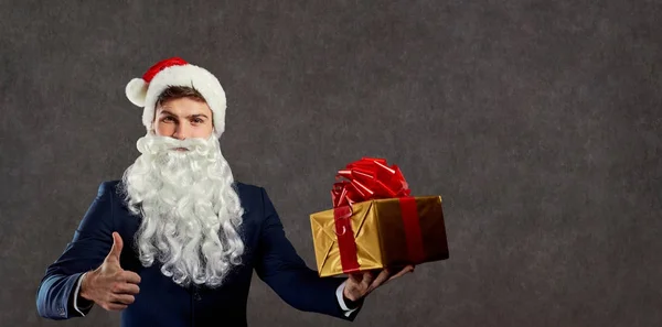 Бизнесмен в костюме Санта-Клауса с подарком в руке . — стоковое фото