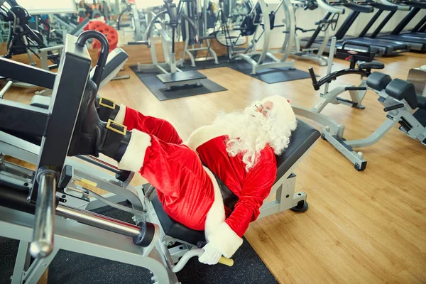 Papai Noel com halteres no ginásio para o Natal . — Fotografia de Stock