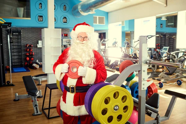 Święty Mikołaj z hantlami w siłowni na Boże Narodzenie. — Zdjęcie stockowe