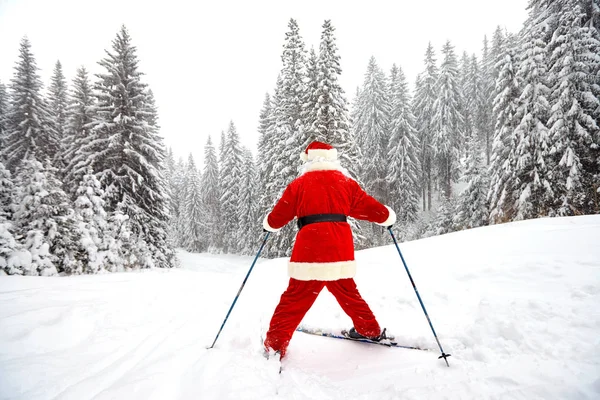 Santa Claus narciarz z nartami w lesie w zimie na Boże Narodzenie — Zdjęcie stockowe