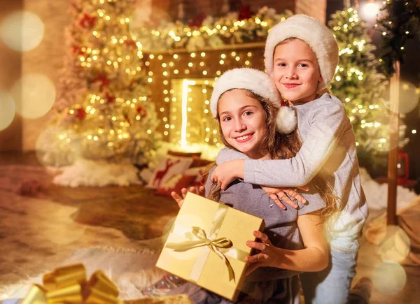 Two children with gifts in a room on Christmas. — Stock Photo, Image