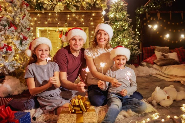 Family with Bengal lights in the room fireplace on Christmas Day — Stock Photo, Image