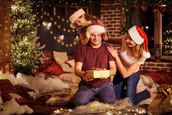 The family gives presents in a room on Christmas Day.