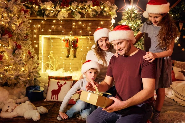 La famille donne des cadeaux dans une chambre le jour de Noël . — Photo