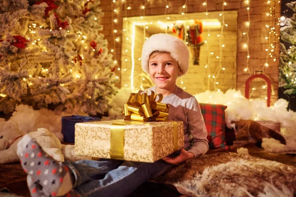 Bir çocukla bir hediye Noel odasında şömine tarafından. — Stok fotoğraf