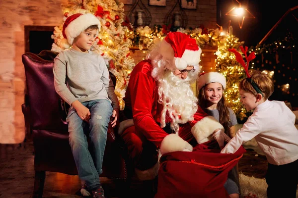 Santa Claus gives presents to children on Christmas Day.