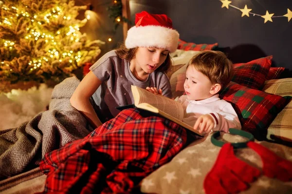 Uma criança está lendo um livro na sala de Natal — Fotografia de Stock