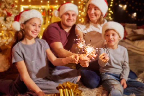 Family with Bengal lights in the room on Christmas Day. — Stock Photo, Image