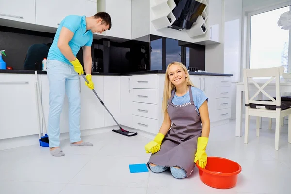 年轻家庭夫妇在厨房打扫卫生 — 图库照片
