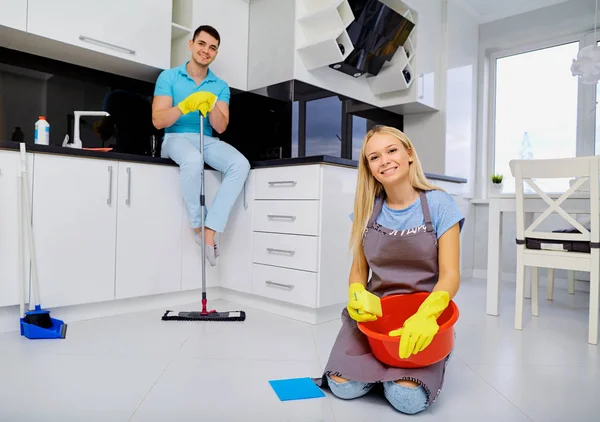 Mladé rodiny pár dělá čištění v kuchyni — Stock fotografie