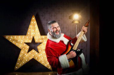 Bir gitar ile mutlu Noel Baba arka planı dans bir