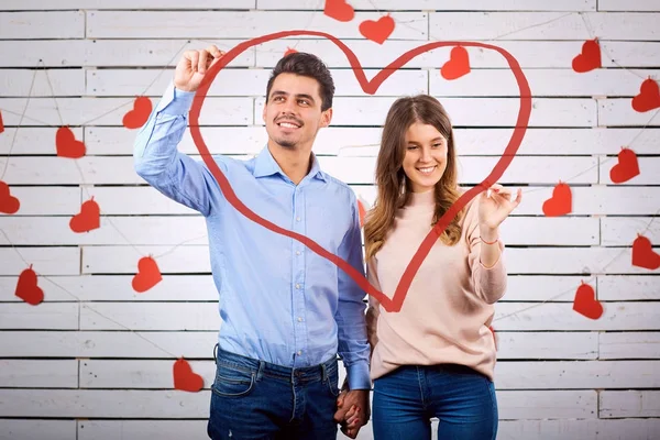 Um casal amoroso atrai o coração com as mãos . — Fotografia de Stock