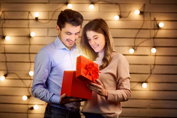 Mladý pár hledá v krabici s dárkem. — Stock fotografie