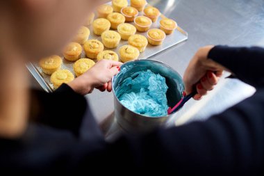 Pudra cupcakes için bir krem mutfak masasında yapar..