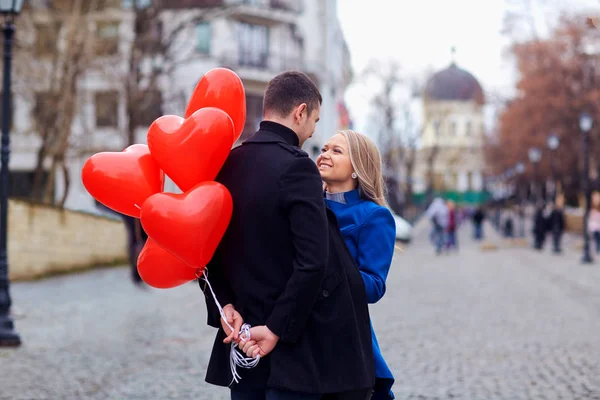 Milující pár s balónky objetí ve městě. — Stock fotografie