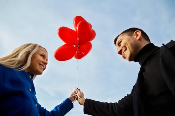 Una pareja amorosa con globos contra el cielo azul . —  Fotos de Stock