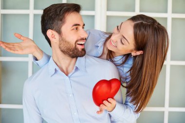 Bir kırmızı kalp gülümseyen ile sevgi dolu bir çift.