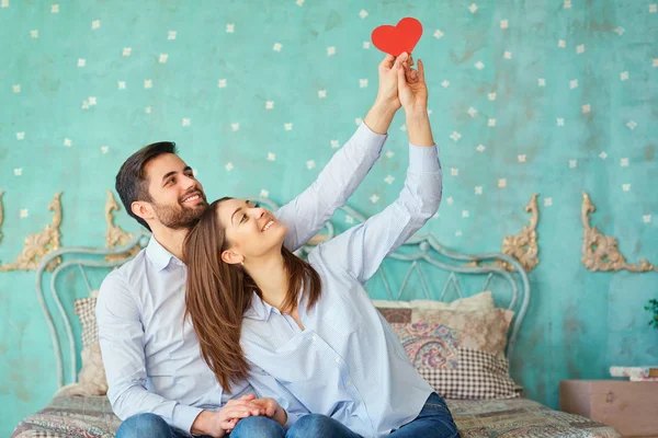 Um casal amoroso com um coração vermelho . — Fotografia de Stock