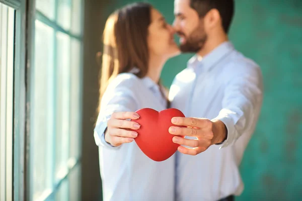 Una pareja amorosa con un corazón rojo sonriendo . —  Fotos de Stock