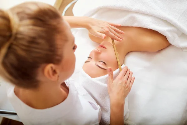 Massage ansikte kvinna sten terapi. — Stockfoto