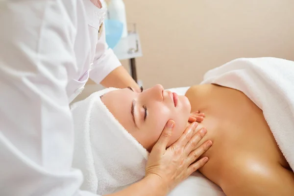 Bella donna a un massaggio facciale . — Foto Stock