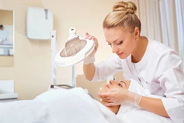 Cosmetologist é um profissional com um paciente no escritório de — Fotografia de Stock