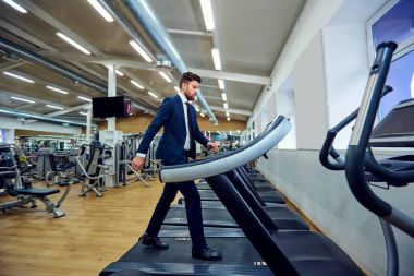 Bir işadamı bir koşu bandı üzerinde yürüyor.