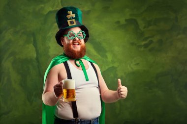 St. Patricks elbiseli sakallı şişman bir adam bir m ile gülümsüyor