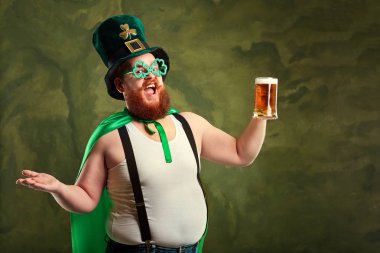 St. Patricks elbiseli sakallı şişman bir adam bir m ile gülümsüyor
