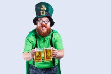 St. Patricks elbiseli sakallı şişman bir adam bir m ile gülümsüyor