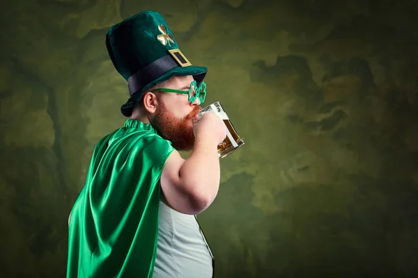 Um homem gordo com barba no fato de St. Patricks está a sorrir com um m. — Fotografia de Stock