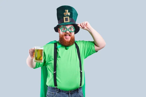 Un hombre gordo con barba en traje de San Patricio sonríe con una m — Foto de Stock