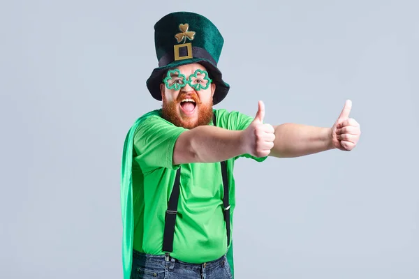 Un uomo grasso con la barba in abito St. Patricks sta sorridendo con un m — Foto Stock