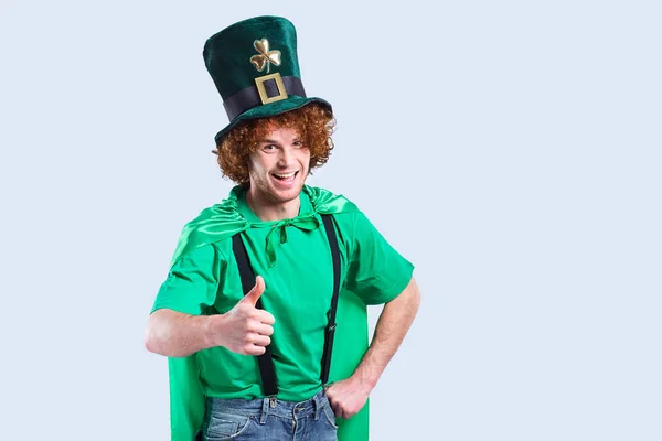 Un giovane uomo dai capelli ricci in abito St. Patricks mostra il suo dito . — Foto Stock