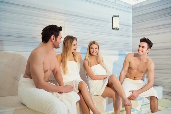 Um grupo de amigos nas toalhas na sauna . — Fotografia de Stock