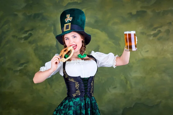 Egy lány, egy korsó sör jelmezre St. Patrick mosolyog. — Stock Fotó