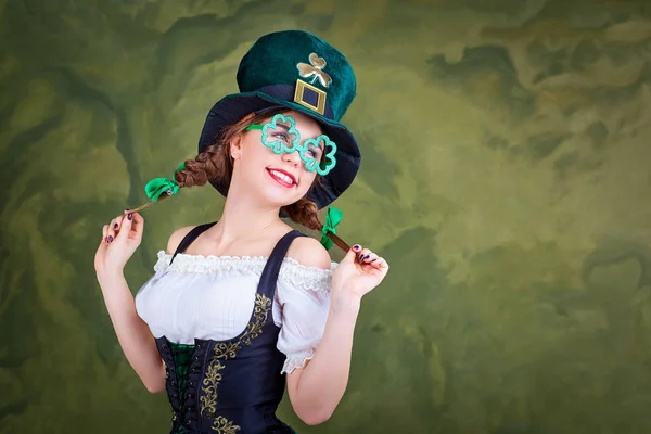 Een meisje in een kostuum van St. Patrick lacht. — Stockfoto