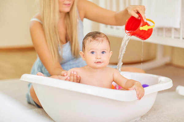 Baby bathing in the bathroom with his mother