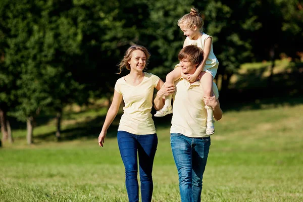 Lycklig familj promenader i parken i sommar — Stockfoto