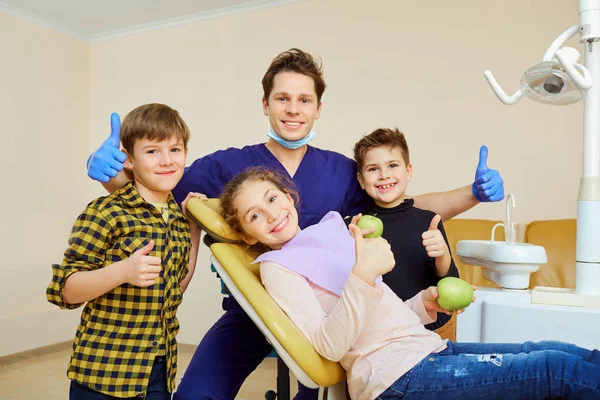 Bir grup çocuk bir erkek gülümseyen bir diş hekimi ile. — Stok fotoğraf