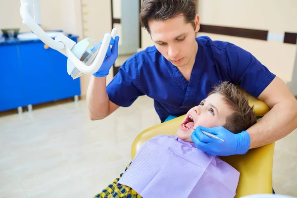 O dentista checando os dentes do menino adolescente . — Fotografia de Stock
