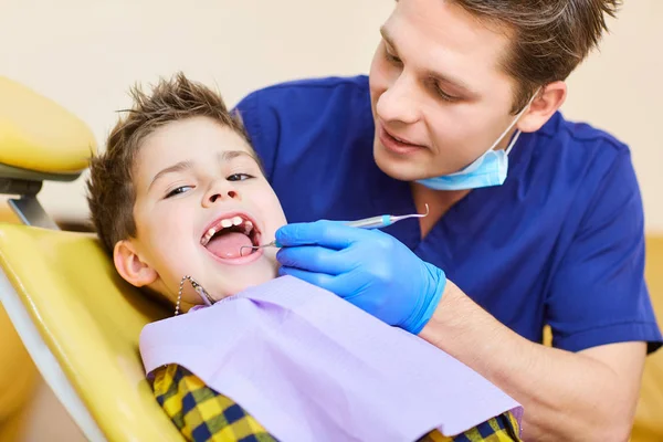 Der Zahnarzt, der die Zähne eines Teenagers überprüft. — Stockfoto