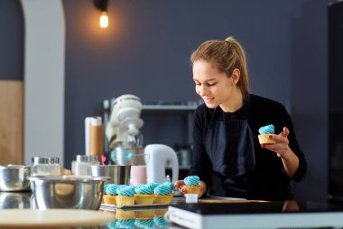 Bir tepsi cupcakes tutan pudra pasta kadın.
