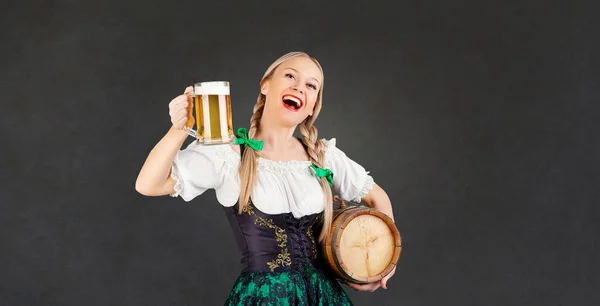 Meisje serveerster oktoberfest in klederdracht met een mok van bier — Stockfoto
