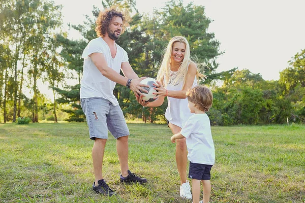 Familia jugando con una pelota en el parque . — Foto de Stock