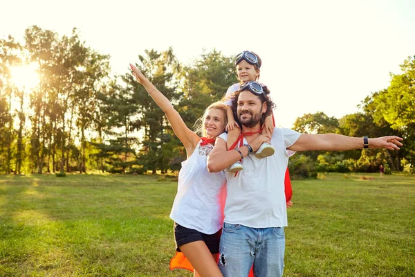 Ευτυχισμένη οικογένεια με κοστούμια των υπερηρώων στο πάρκο. — Φωτογραφία Αρχείου