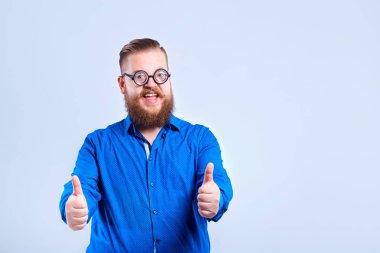 Bir posi olarak gri arka plan üzerinde gözlüklü şişko, sakallı bir adam